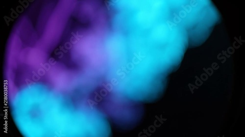 Blurred blue and purple ink clouds swirling in water against black on transparent background