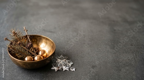 Bronze Bowl With Conifer Branches in grey background Christmas concept 