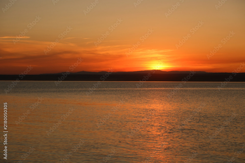 Obraz premium Soft pink and orange sunset over quiet waters and sandy shore in East Kazakhstan. Minimalistic