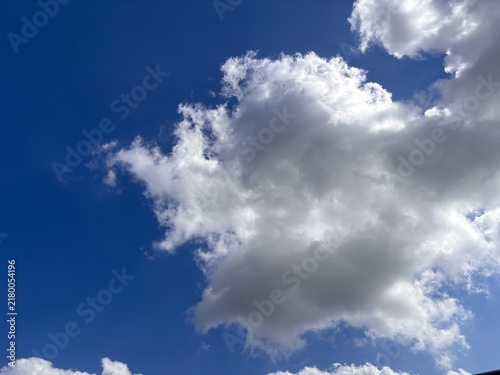 Beautiful bright blue sky landscape with fluffy white cumulus clouds. Natural weather background template for outdoor concept, clean environment banner, and peaceful summer atmosphere.
