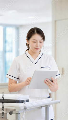 Obraz w ramie 病院の作業台でタブレットに記録する看護師