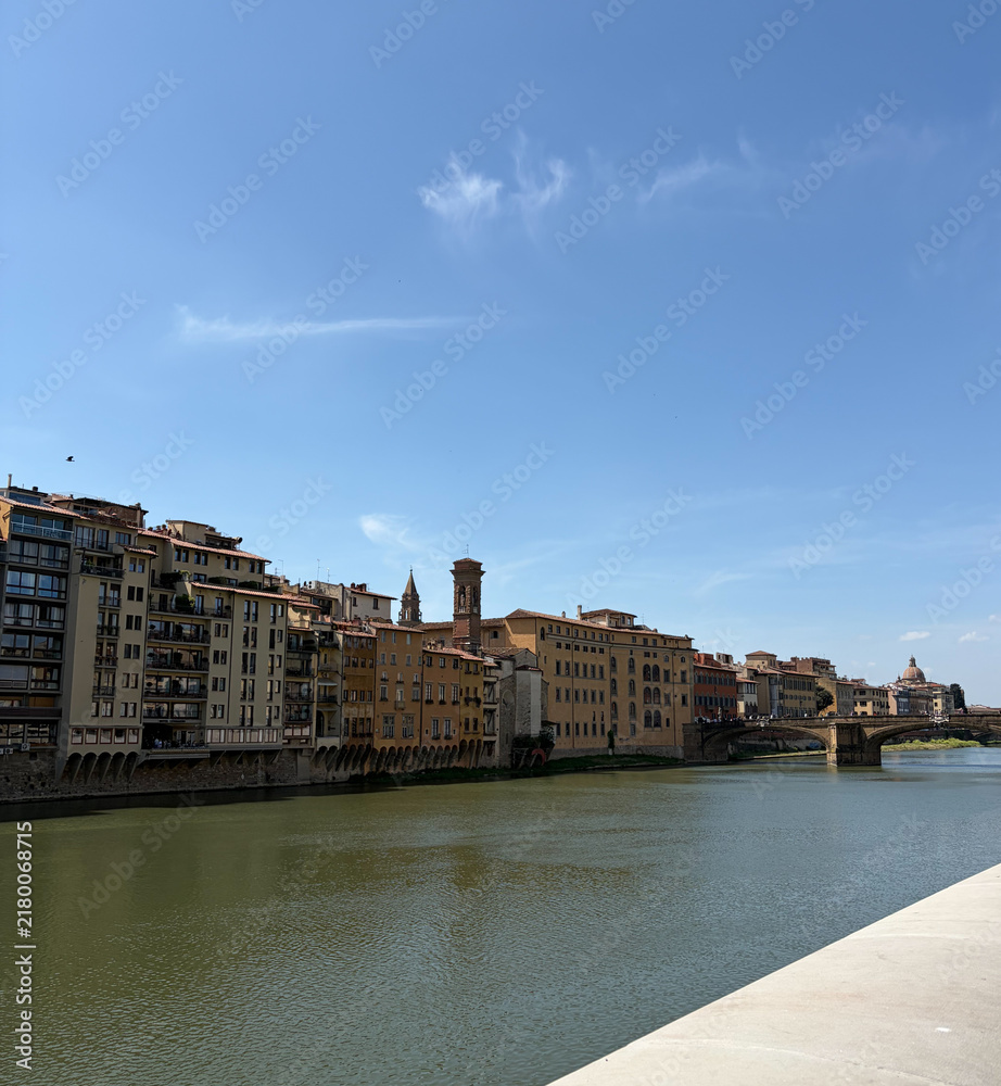 Obraz premium Arno River with Historic Buildings and Bridge in Florence Italy