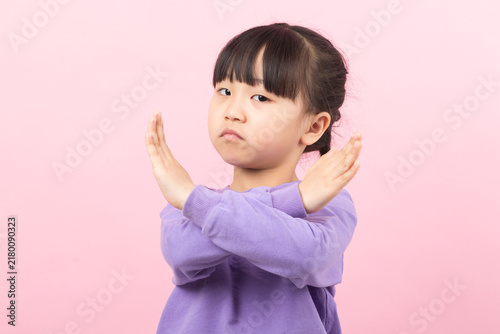 Obraz na plátně Serious little girl showing a cross sign with her arms as a gesture of refusal