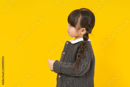 Fotografie Stubborn little girl turning away and looking back with a grumpy side profile expression