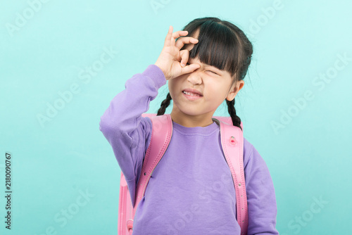 Cuadro en lienzo Playful little girl making a funny face with hand gesture over eye, creative and mischievous childhood