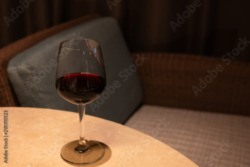 Glass of red wine on a table indoors.