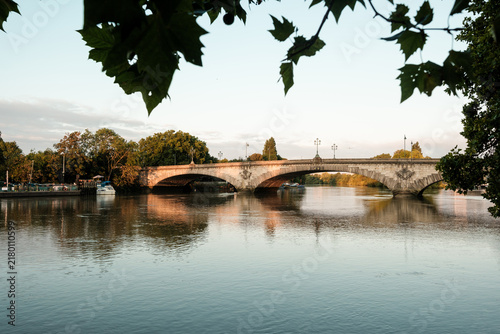 Photography Kew bridge arching over river thames at sunset