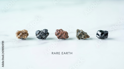 Rare earth elements supply displayed as five unprocessed mineral specimens on white surface with subtle educational text and clean spacing