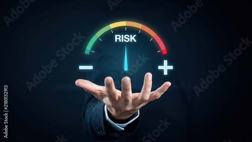 A businessman holds a glowing risk meter measuring financial exposure and uncertainty. This conceptual image is ideal for corporate risk management presentations.