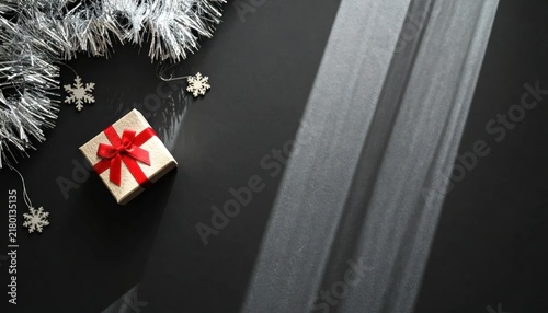 Small Wrapped Gift Box with Red Bow on Dark Festive Holiday Table