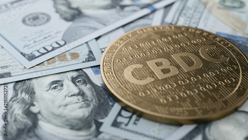 CBDC Coin Resting on Scattered US Dollar Banknotes. 3d rendering