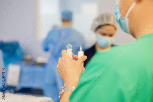 Bild auf Leinwand Doctor con una jeringa con anestesia en la mano antes de que empiece la operació