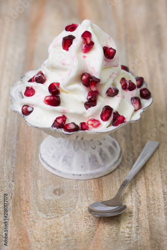 Cremiges Softeis mit frischen Granatapfelkernen in einer Vintage Schale