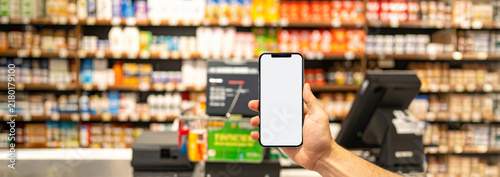 スーパーマーケットのレジ前で白画面のスマートフォンを持つ手