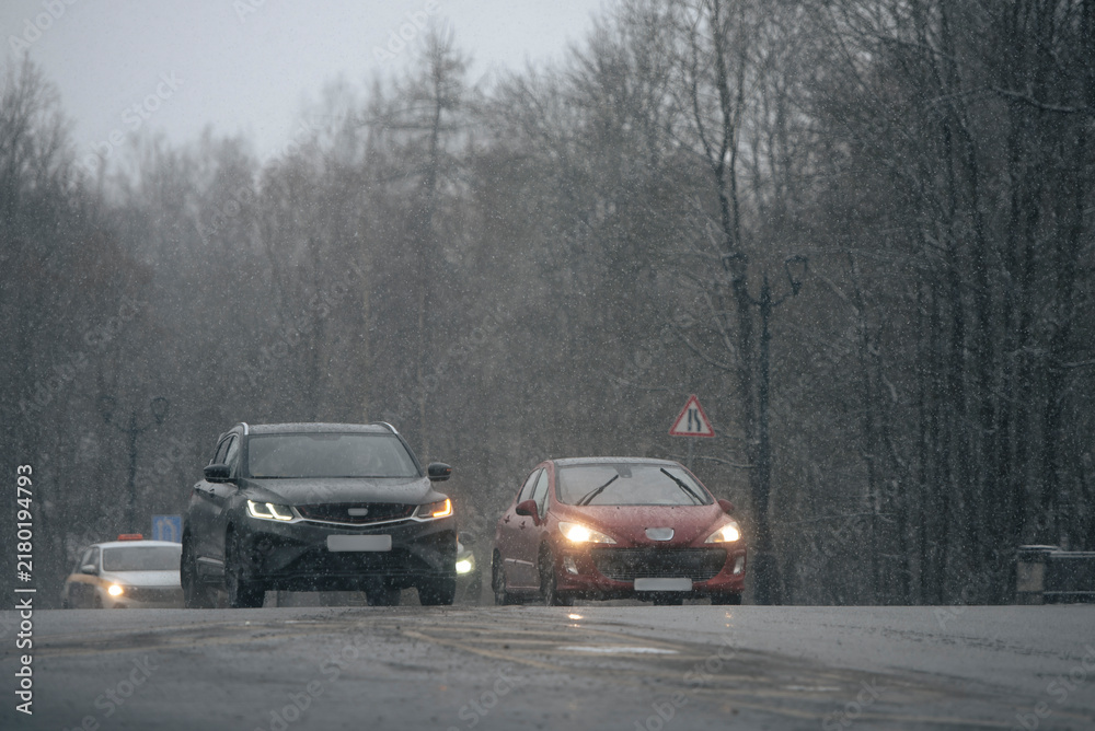 Fototapeta premium Heavy Snowfall Traffic on Wet Winter RoadRussia, Leningrad Region, 2025.