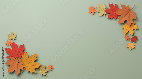 Colorful autumn maple leaves forming a frame on a soft green background