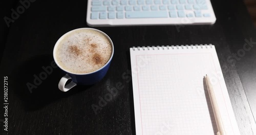Keyboard and coffee cup on a dark table, as a business backdrop

