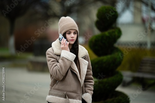 Obraz na płótnie Young woman enjoying a serene winter stroll while engaged in a heartfelt convers