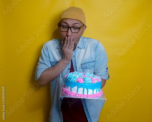 Young Adult Male Looking At Sweet Cake, Covered His Mouth With Hand Showing Surprise Expression