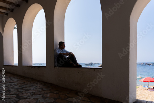 Quadro su tela Man contemplating ocean view from an archway, enjoying peaceful solitude during