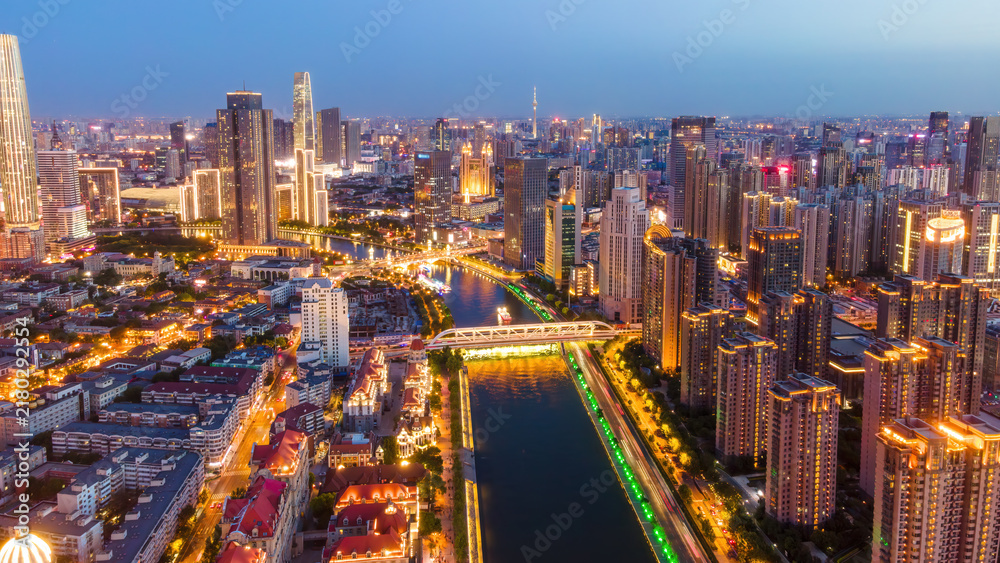 Fototapeta premium Twilight Cityscape with River and Modern Bridges