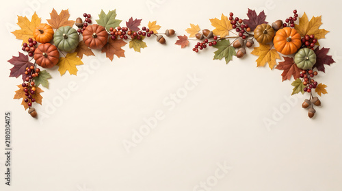 Decorative autumn garland border featuring colorful fall leaves and small pumpkins isolated on a plain white background space