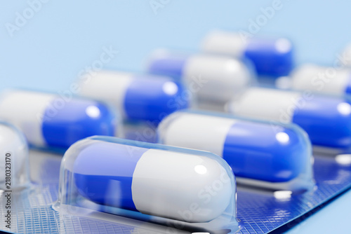 A blister pack contains blue and white capsules for medical treatment