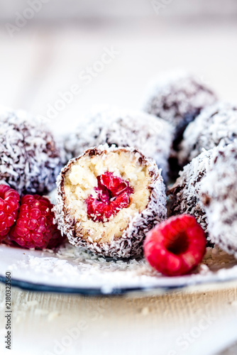 Lamington bliss balls with cashews, filled with raspberries, dark chocolate and coconut flakes