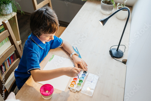 Young boy painting with watercolors developing creativity