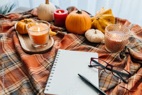 Autumn hygge concept with notebook and lit candles