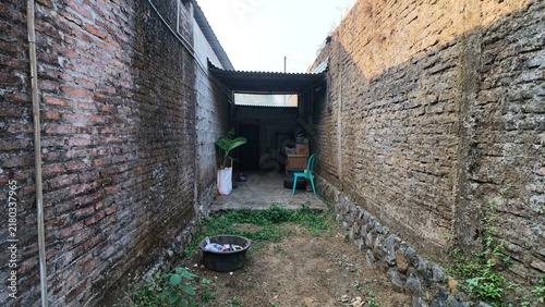 Foto View down a narrow alley between weathered brick walls with small