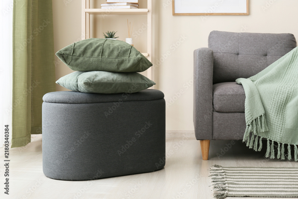 Obraz premium Home interior design and comfort, green pillows on a grey ottoman in a cozy living room with modern furniture and soft textiles for relaxation