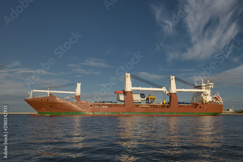 Quadro su tela MARITIME TRANSPORT - The ship is sailing out to sea with a wind turbine on board
