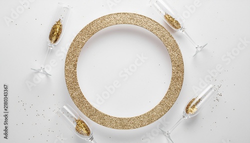 Elegant Gold Decorated Dinner Plate Surrounded by Champagne Glasses.