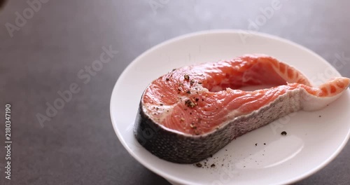 Grilled salmon steak on a white plate, minimalist food styling.
