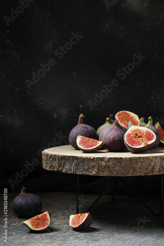 Naklejka Wooden stand with fresh ripe figs on grunge table