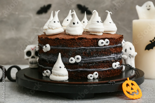 Sweet Halloween cake decorated with meringue ghosts, spider, skull and pumpki...