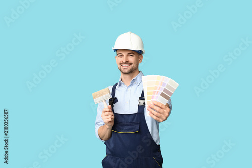 Fotografie Portrait of male painter with brush and color palettes on blue background