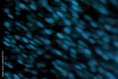 Fotografía Against a midnight-blue background, oblong drops of pale blue light fall diagona