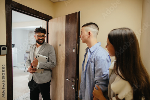 Real estate agent meeting young couple for apartment showing