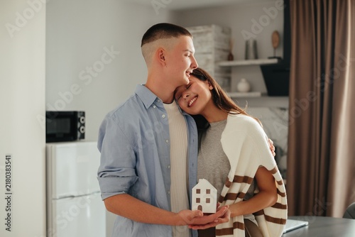 Obraz na płótnie Young couple holding house model envisioning home ownership