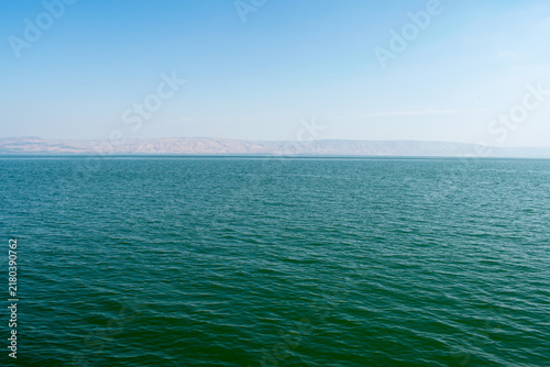 Calm turquoise waters of the Sea of Galilee stretching toward distant hills