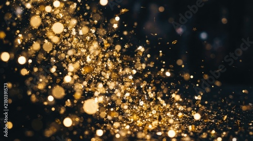 Swirling Golden Glitter Confetti and Sparkling Bokeh Lights on Dark Festive Background