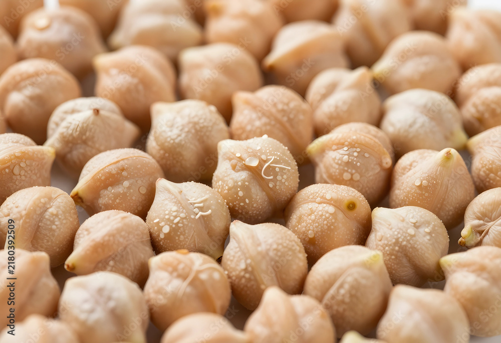 Fototapeta premium Healthy nutrition and plant based protein, raw chickpeas with water droplets for vegan diet and sustainable food source in a high resolution macro shot
