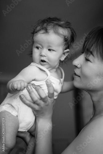 Foto A mother tenderly kisses and hugs her baby in a pink bodysuit