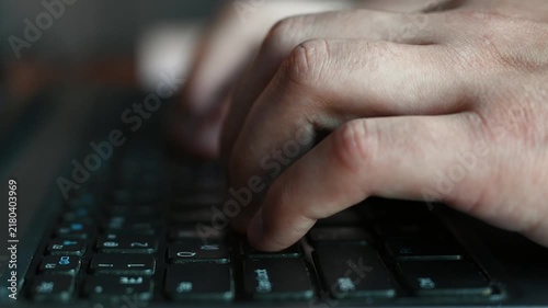 The hands are actively typing on the keyboard, fingers moving over the keys. The persons hands are busy typing, pressing the keys with steady rhythm.