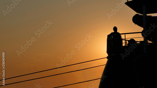 Foto silhouette of a line handler man standing on stern working on a ship casting off