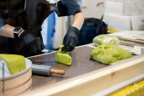 Close-up image of a woman making pastries at the counter
