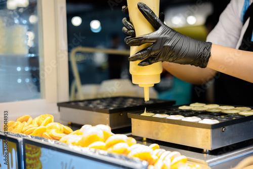 Close-up image of a woman making pastries at the counter