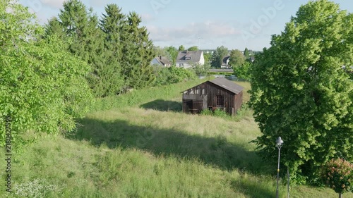 Green lawn and an old wooden barn outdoors village landscape